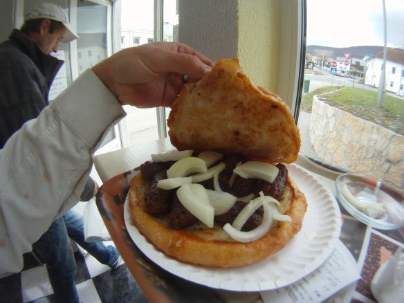 Cevapi, greasy sausage links and onions between two Croatian pancakes