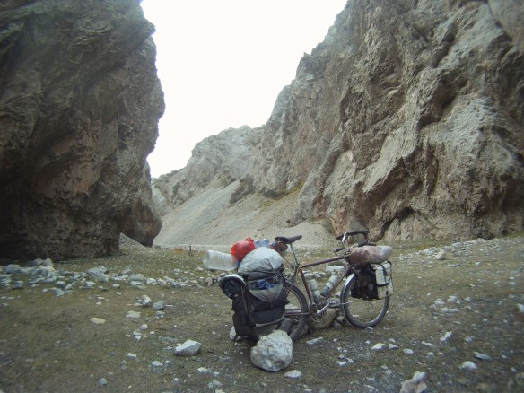 Packing up to leave valley where I built rock walls to protect from wind, large rocks are propping up Gaby
